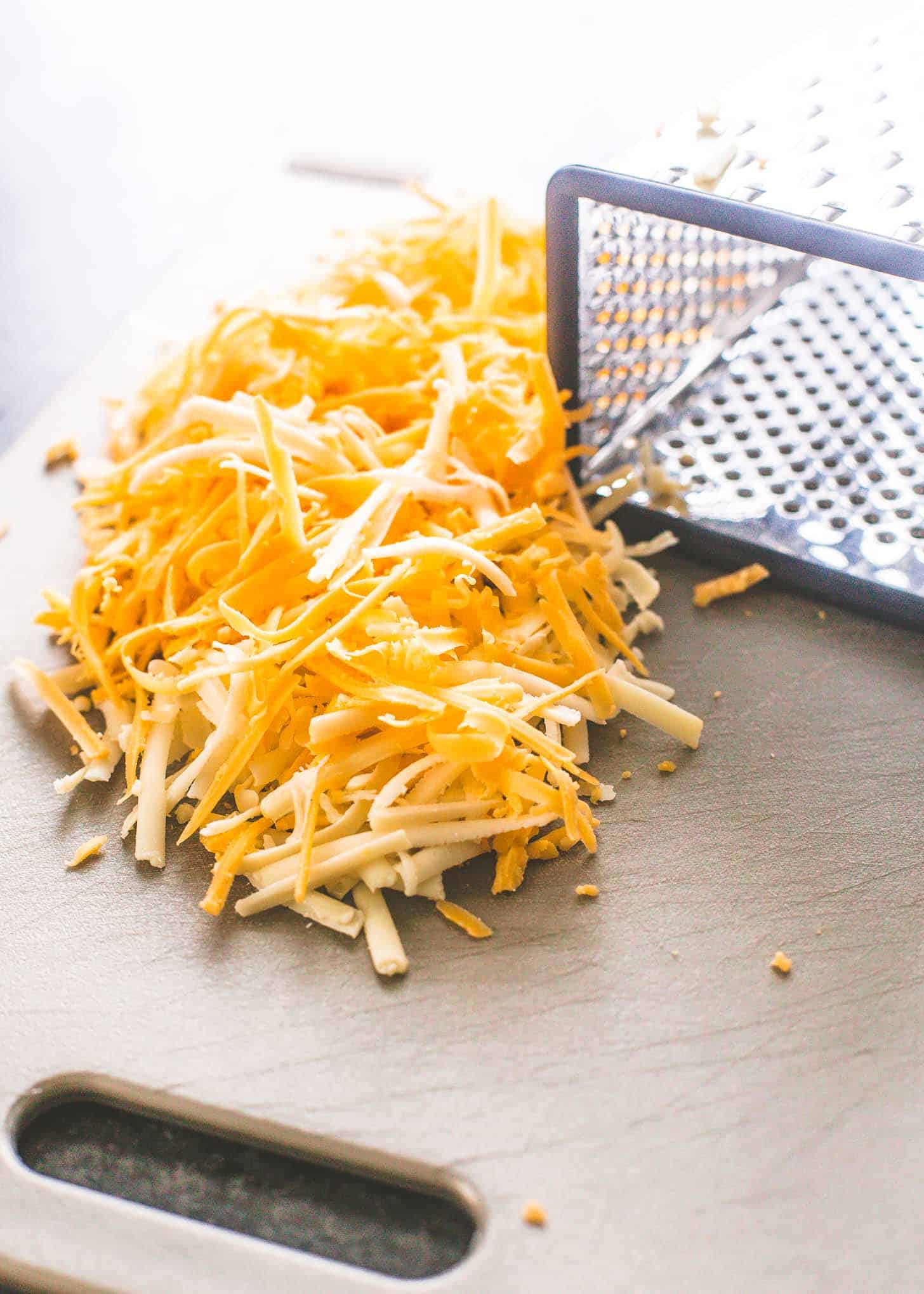 shredded cheese on a grey cutting board