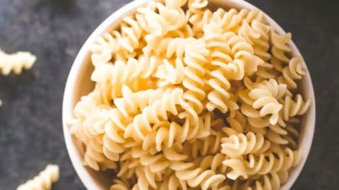 cooked pasta in a white bowl on a grey countertop