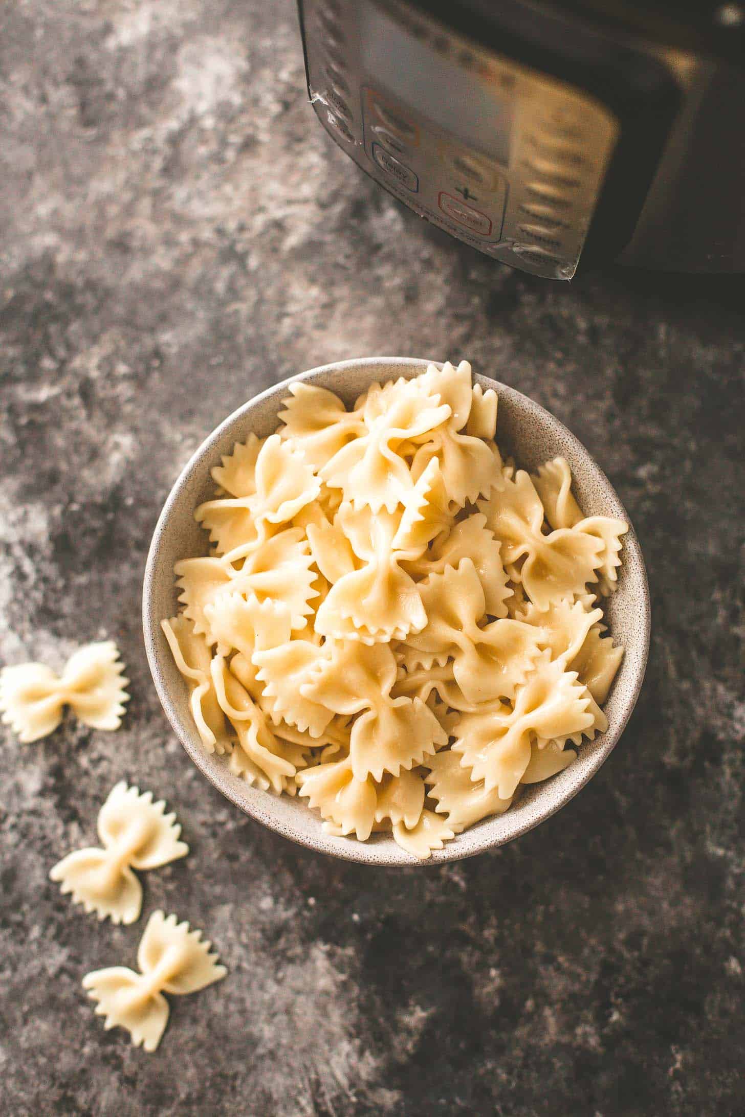 cooked pasta in a white bowl on a grey countertop