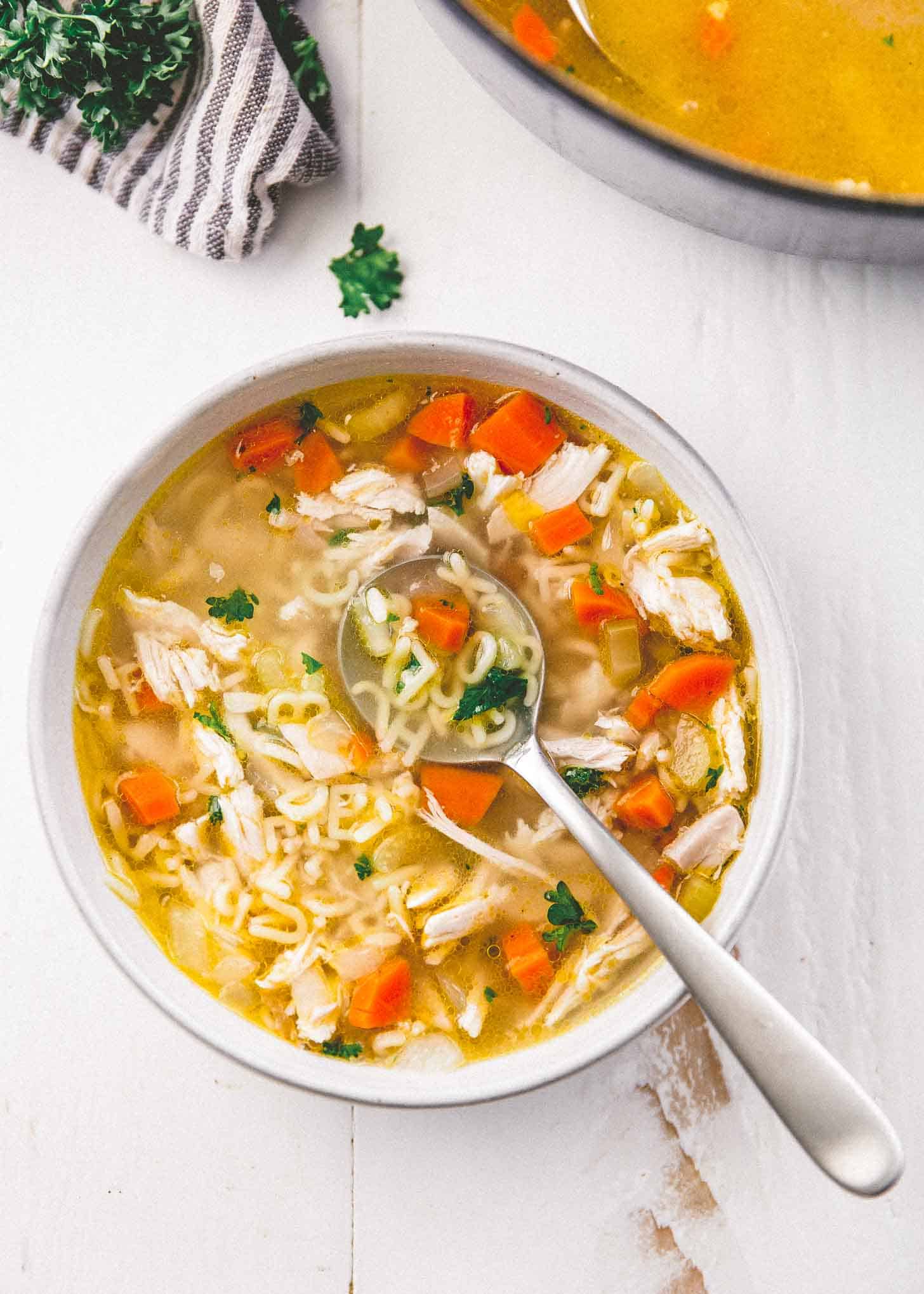 overhead image of chicken noodle soup in a white bowl