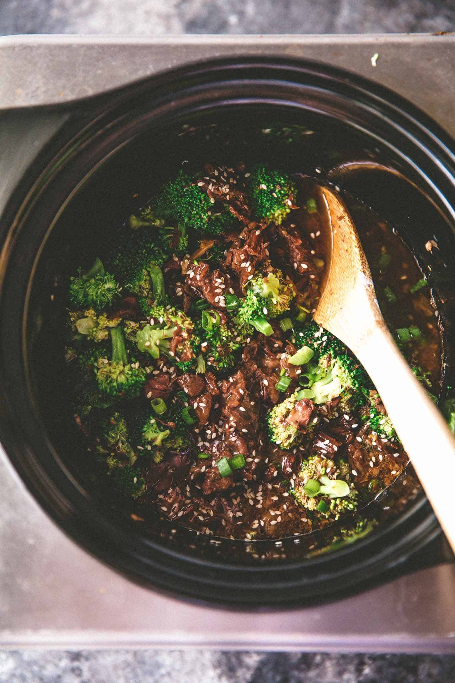 overhead image of stirring beef in a slow cooker