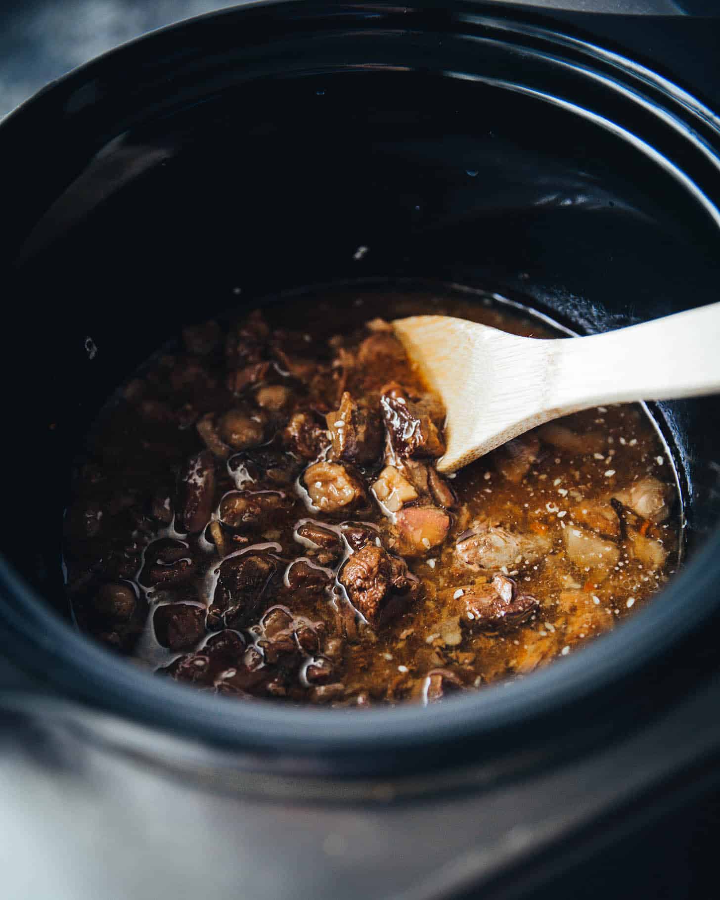 stirring beef in a slow cooker