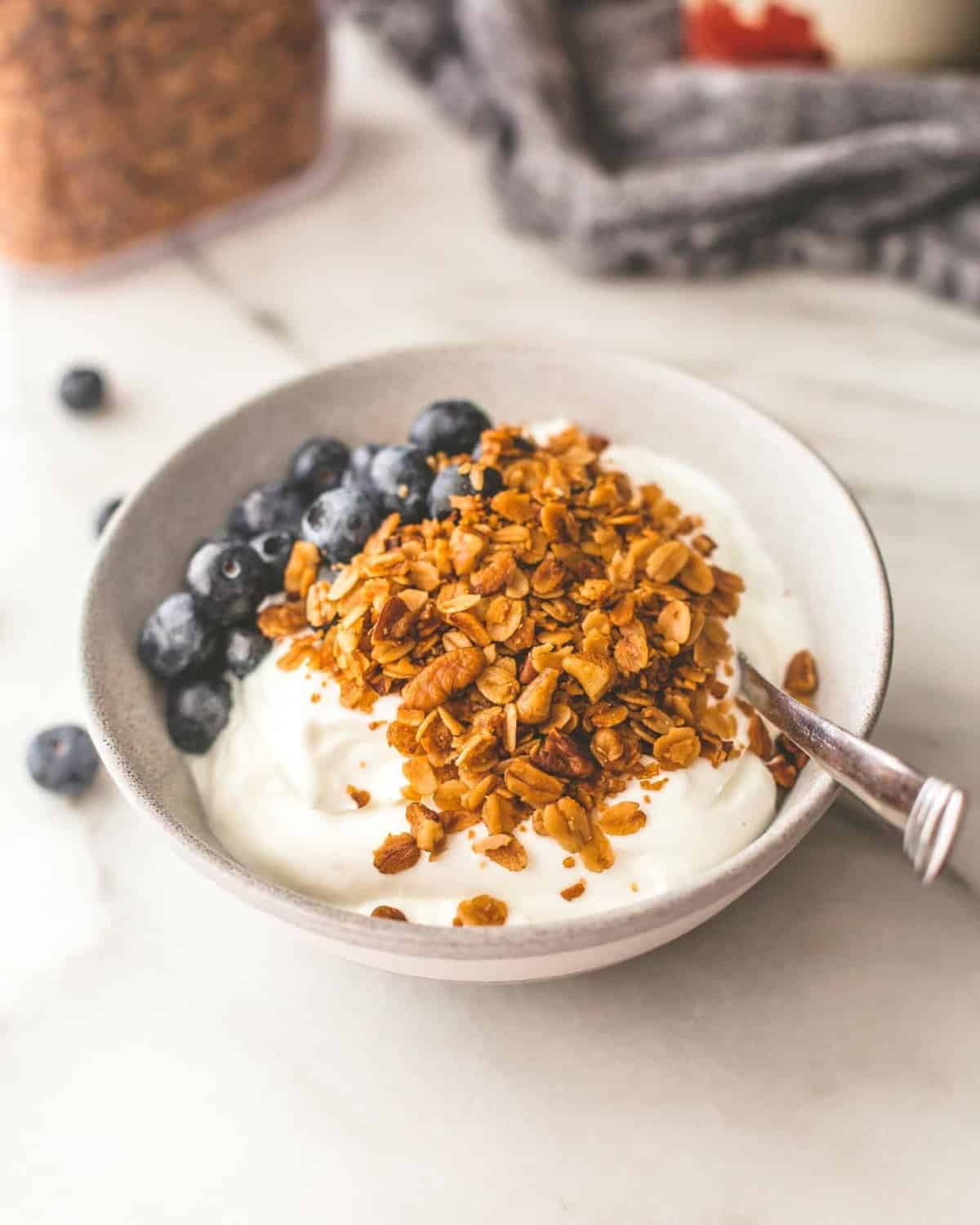 slow cooker granola over yogurt in a white bowl