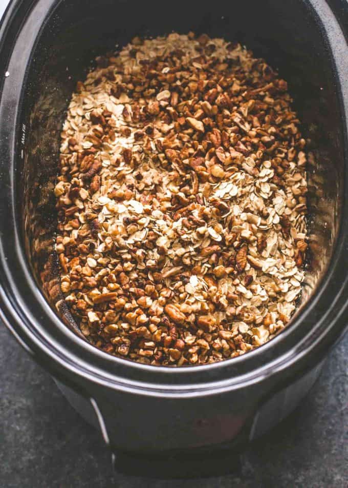 adding ingredients to granola in the slow cooker