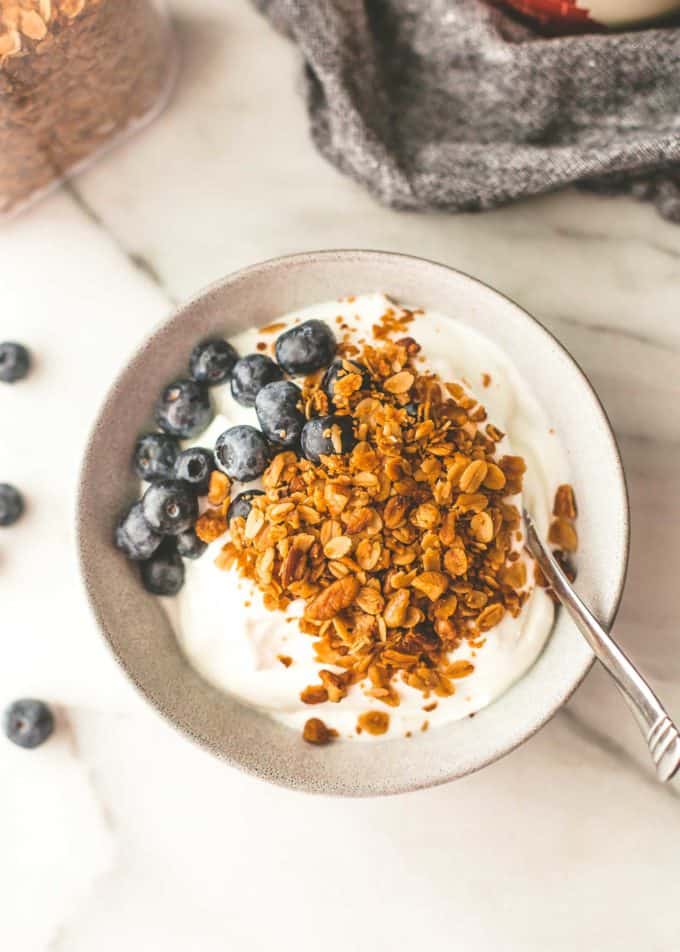 granola and blueberries topping yogurt in a bowl