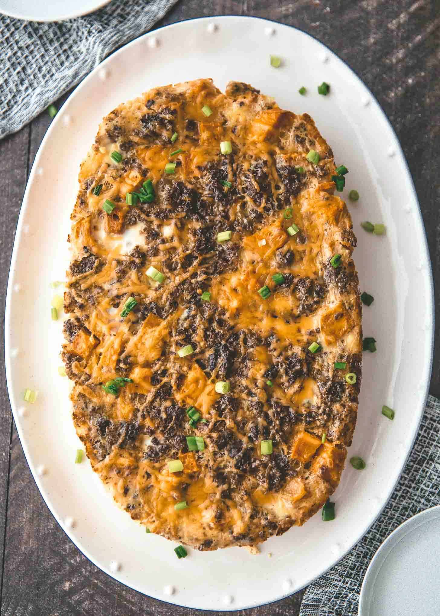 overhead image of slow cooker breakfast casserole on a white oval tray