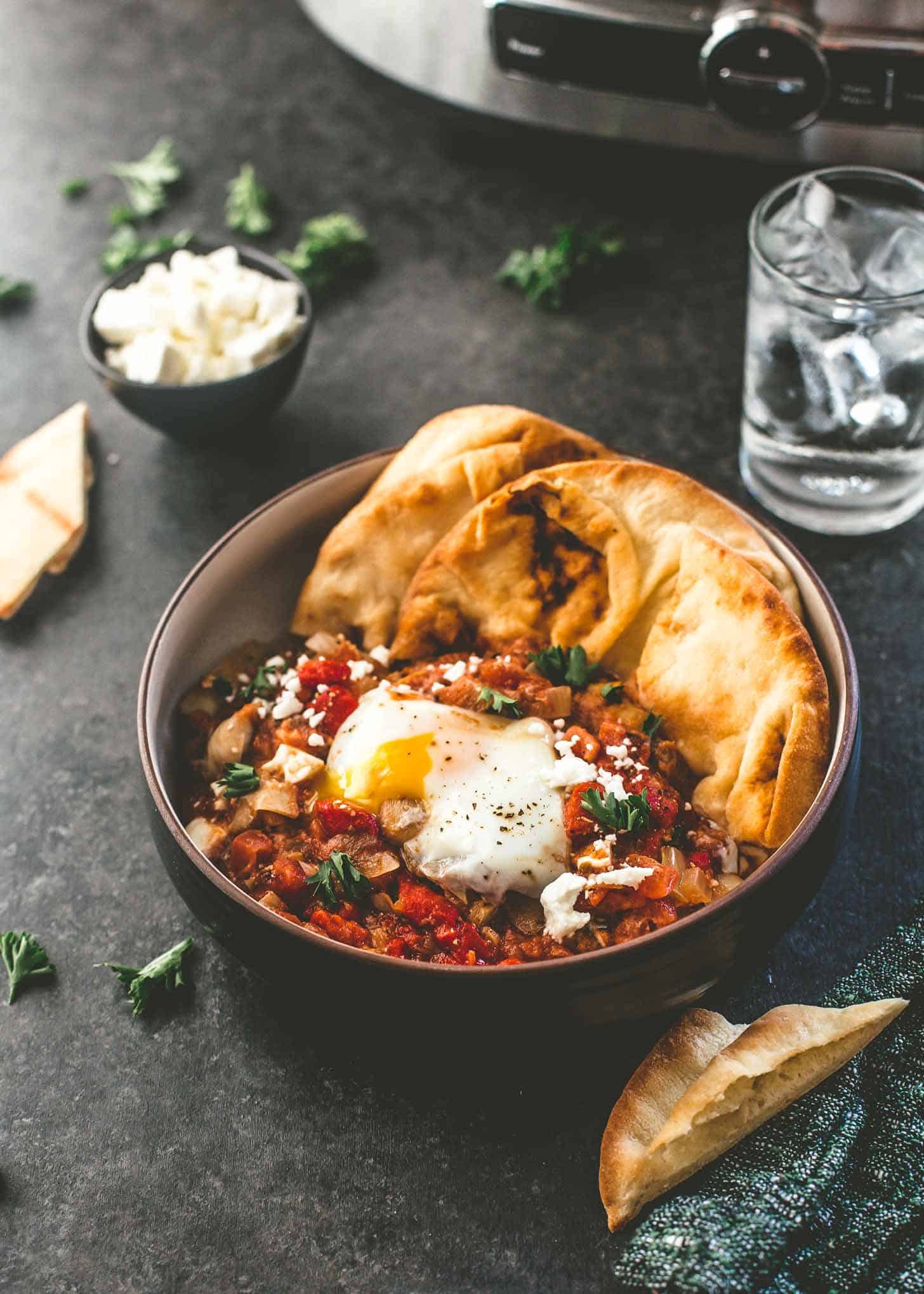 slow cooker shakshuka in a bowl with naan