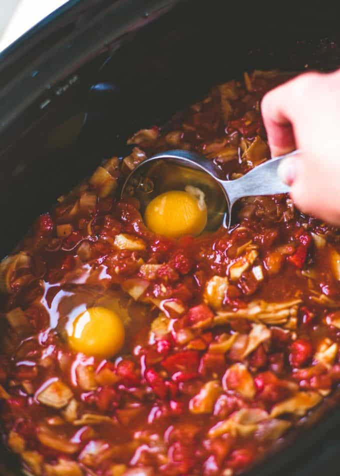adding eggs to slow cooker shakshuka