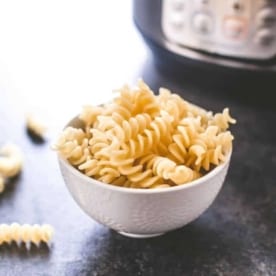 cooked pasta in a white bowl on a grey countertop