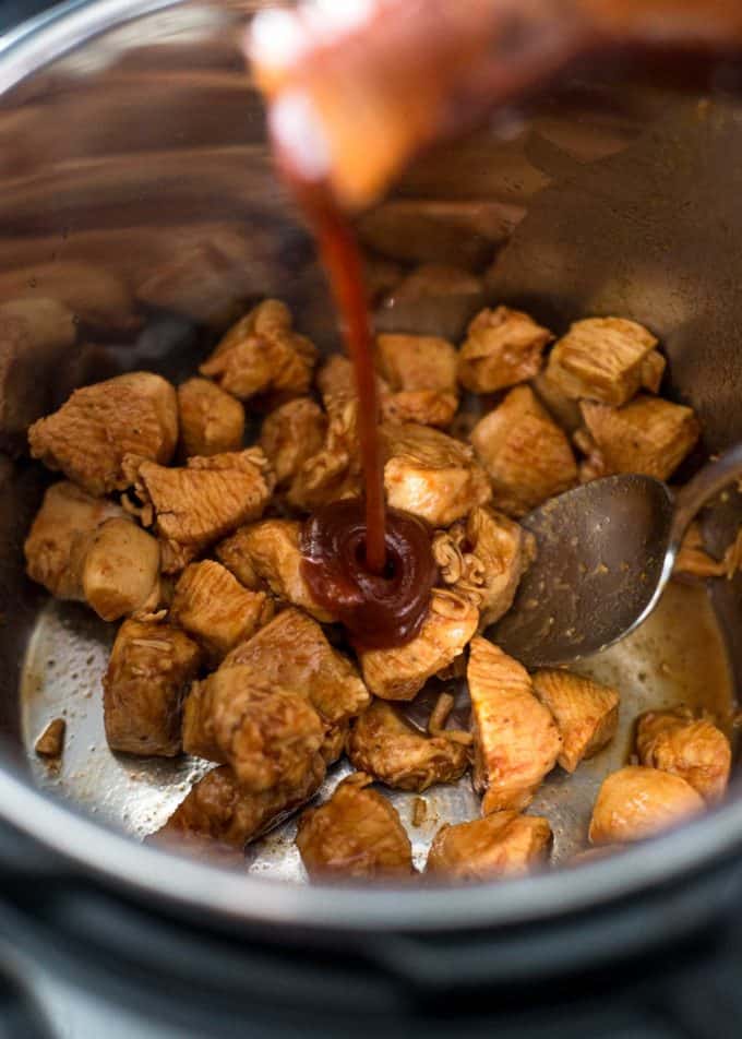 adicionando molho de churrasco ao frango em uma panela instantânea