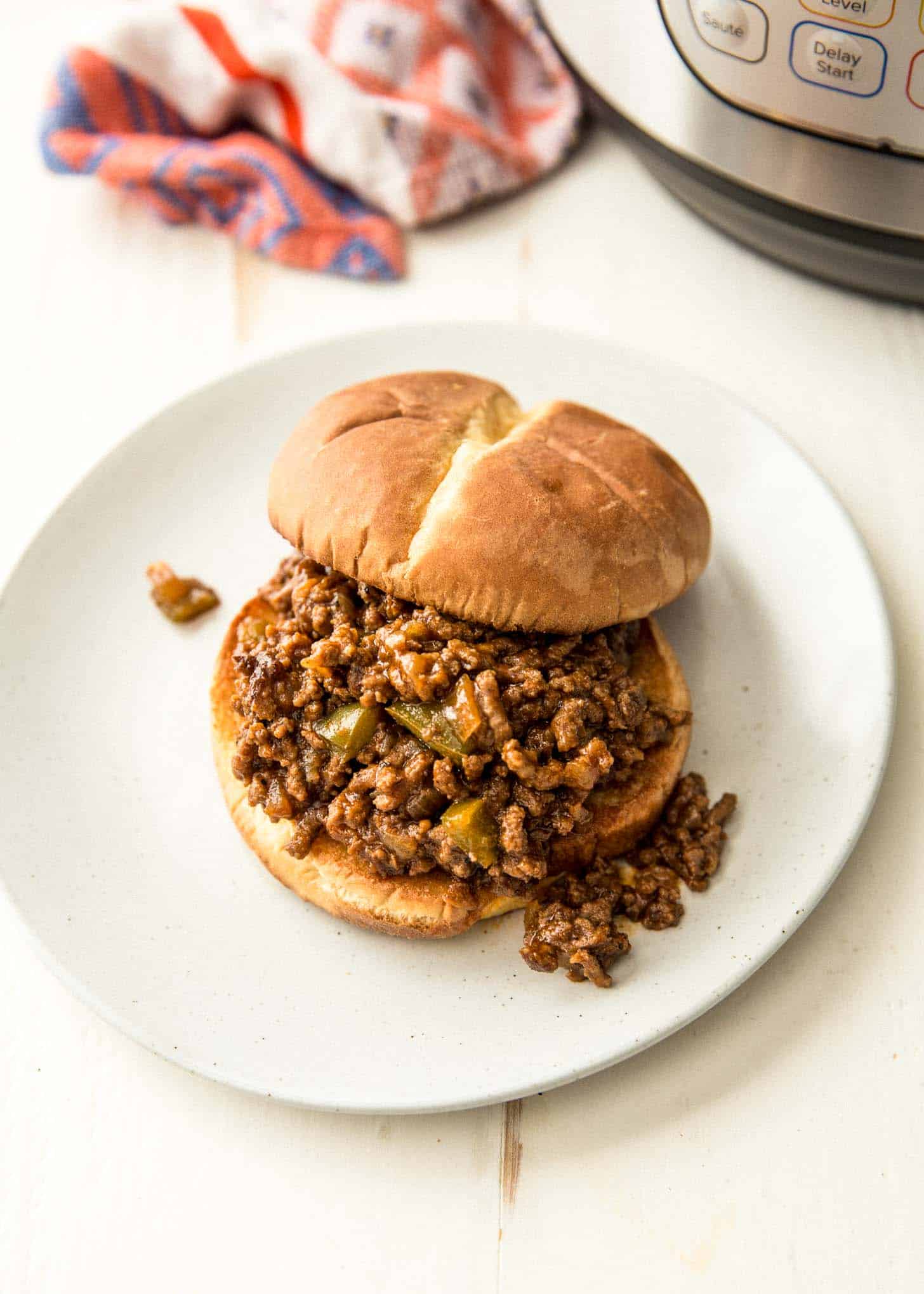 sloppy joes on a bun on a white plate