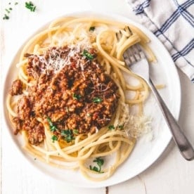 Simple Beef Ragu over spaghetti on a white plate