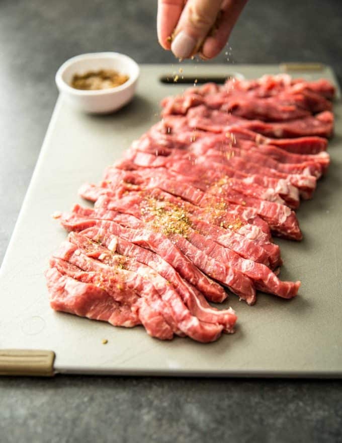 seasoning uncooked steak pieces