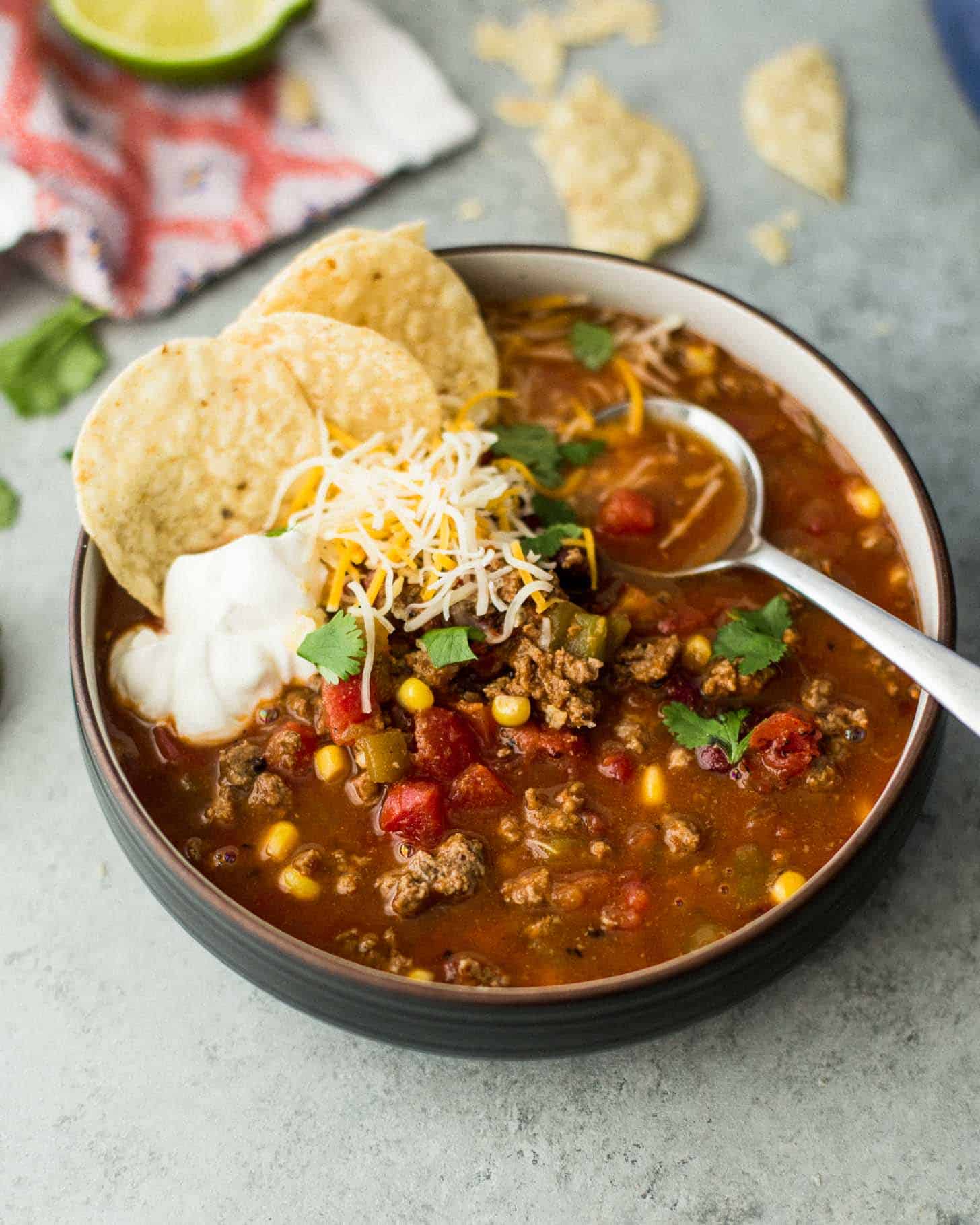 a bowl of taco soup with sour cream and tortilla chips