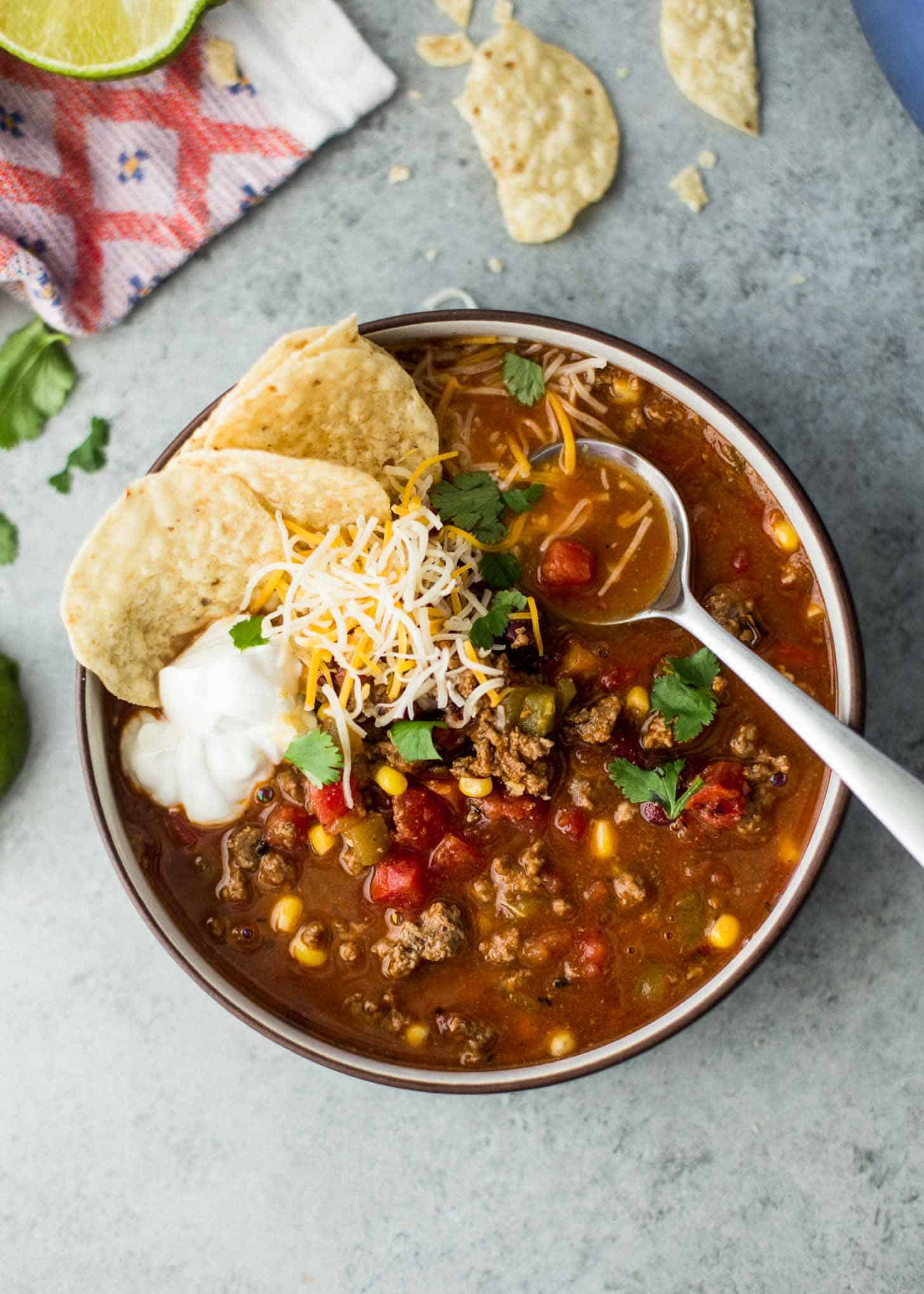 overhead image of taco soup with ground beef in a bowl with tortilla chips