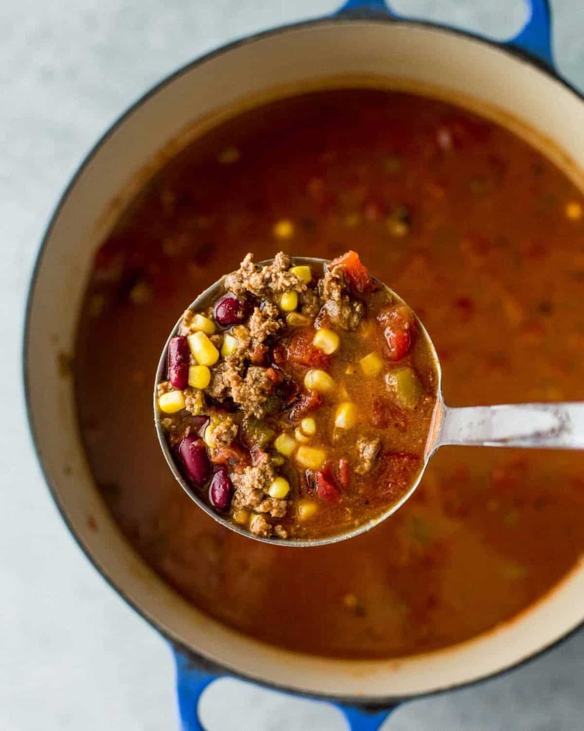 a spoonful of taco soup above a dutch oven