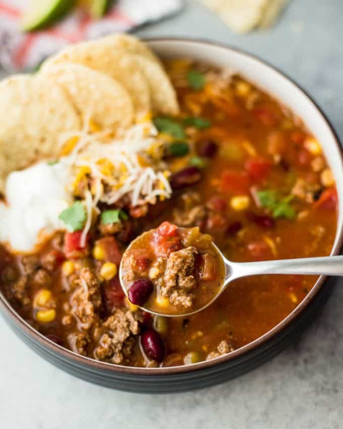 a bowl of taco soup with ground beef and a spoon