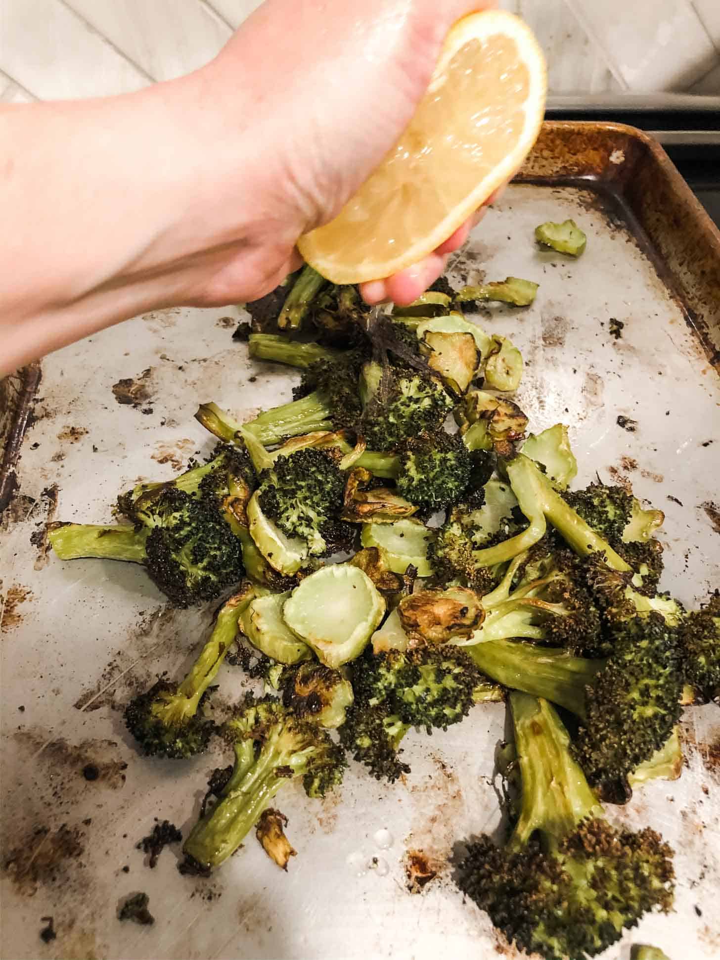 squeezing lemon on roasted broccoli