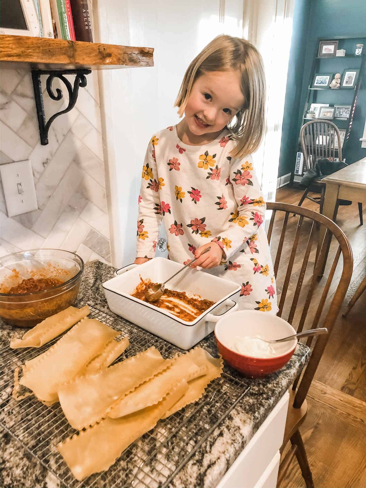 little girl stirring sauce at a table