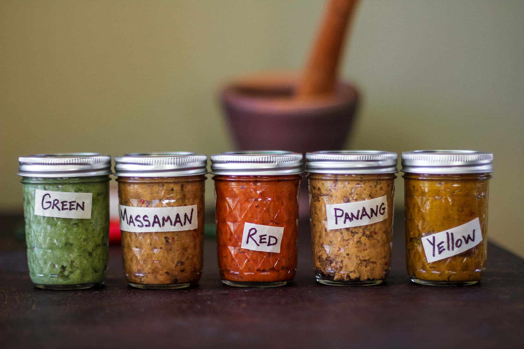 Mason jars of curries -- green, massaman, red, panang and yellow