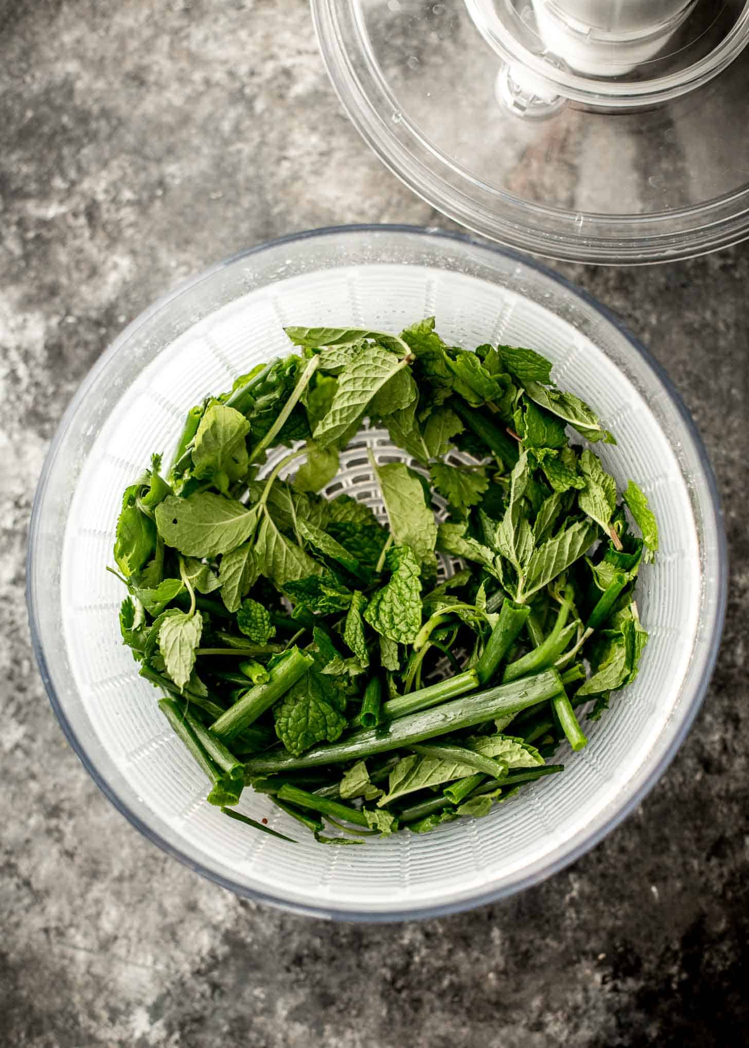 overhead image of fresh herbs in a salad spinner