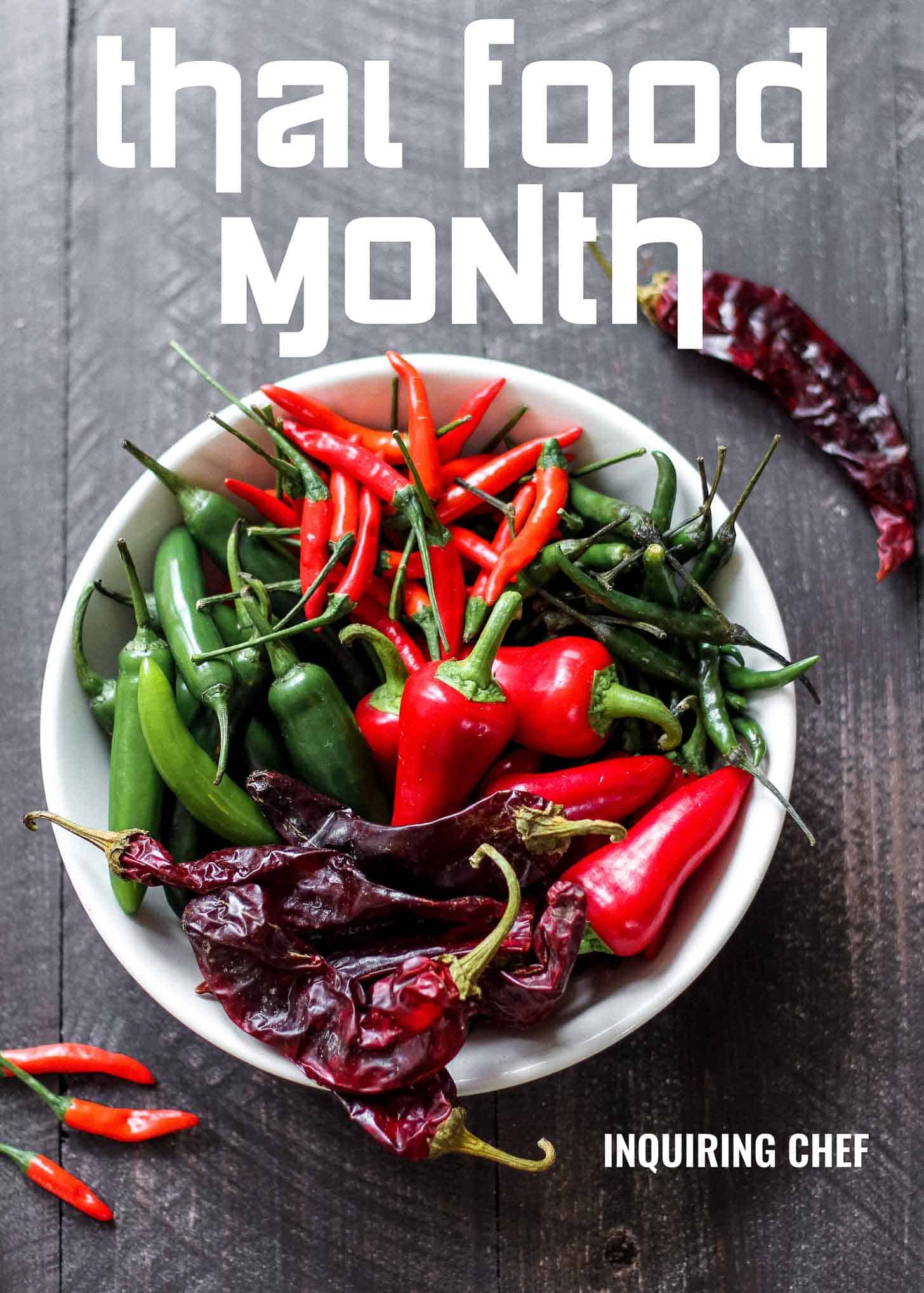 a bowl of different chili peppers on a grey tabletop