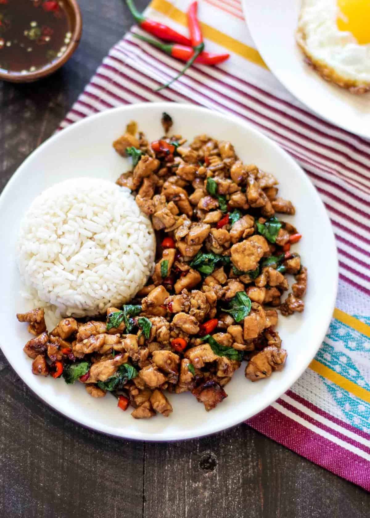 thai basil chicken with rice on a white plate