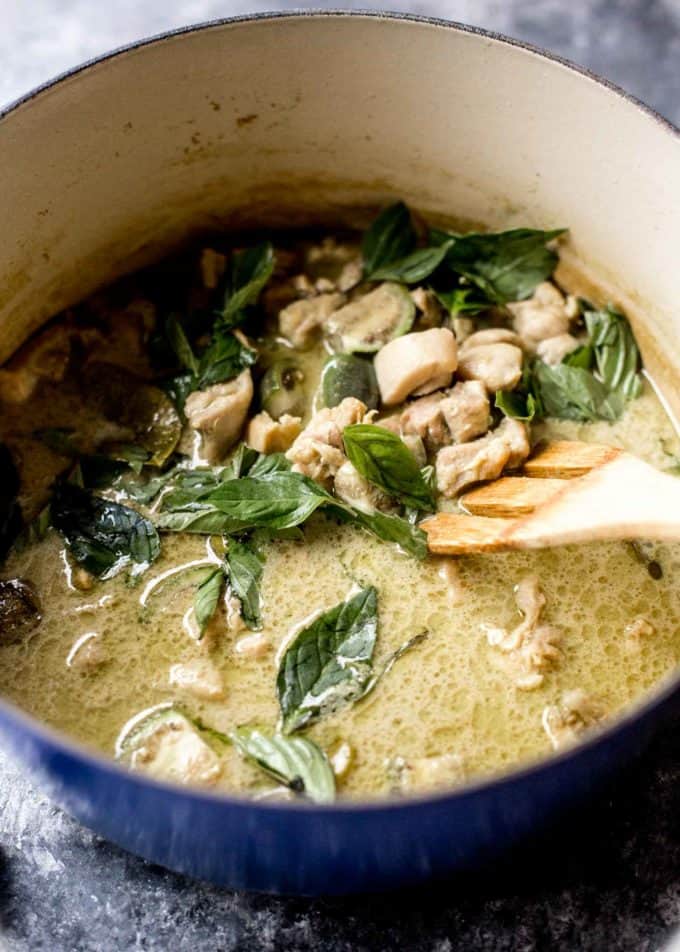 thai green curry in a blue dutch oven with a wooden spoon