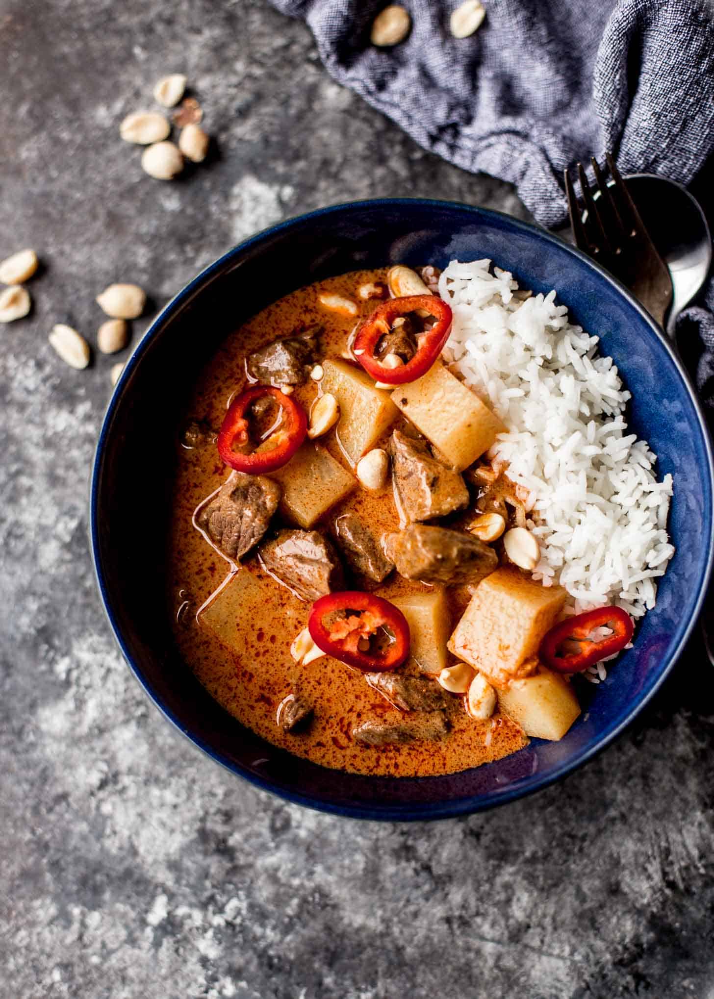 overhead image of Thai Massaman Curry in a blue bowl over rice