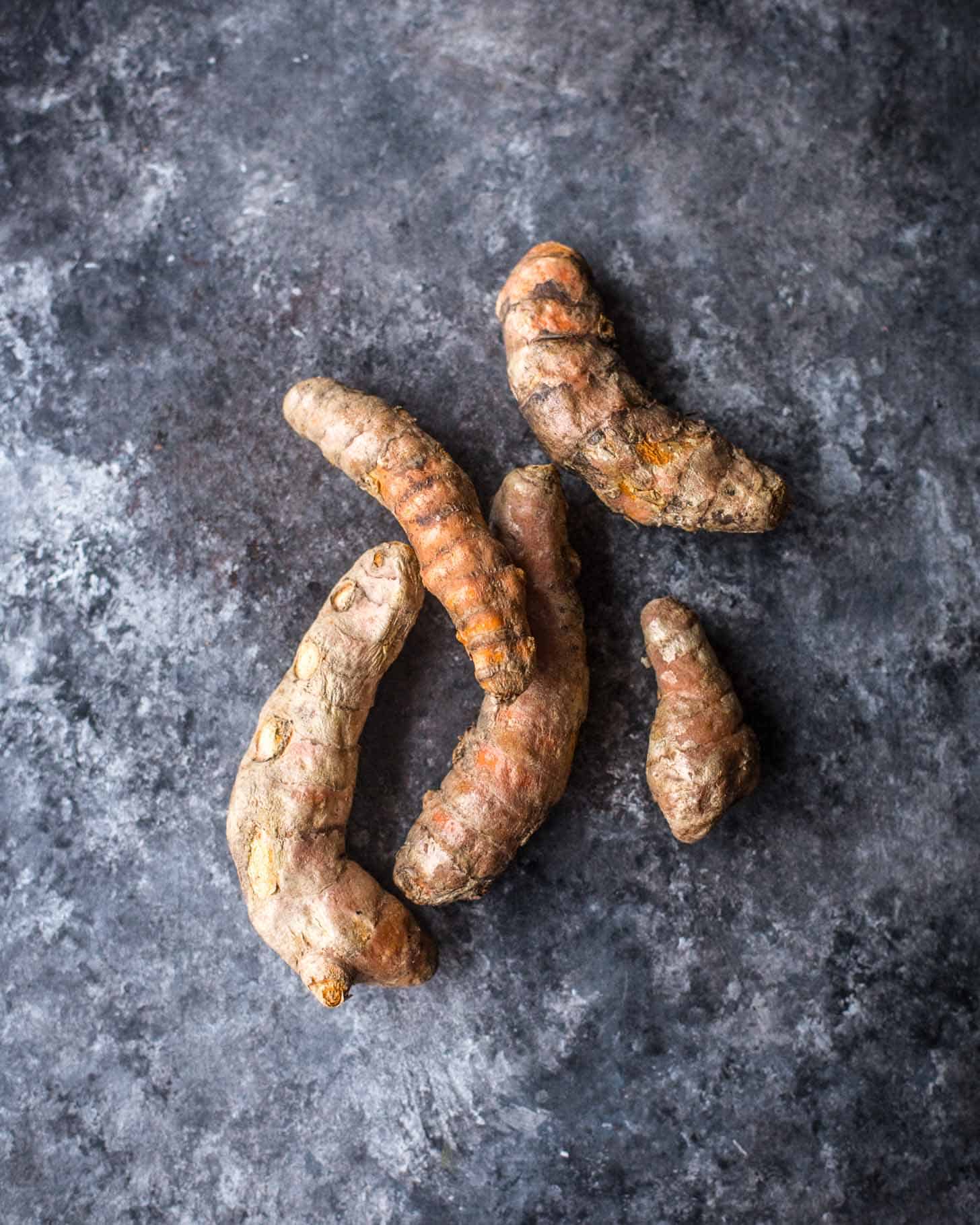 overhead image of fresh turmeric on a grey tabletop