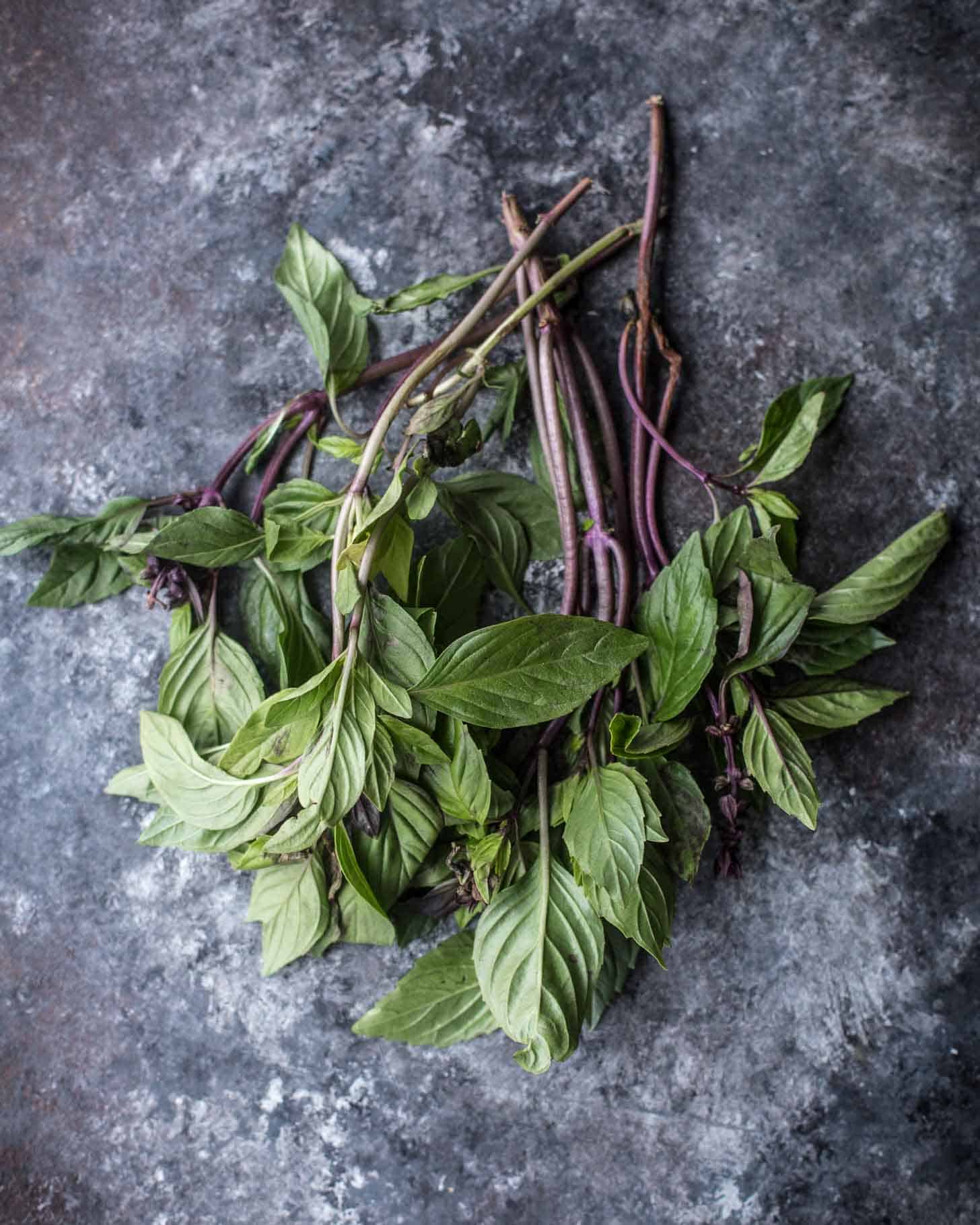 overhead image of thai basil on a grey tabletop