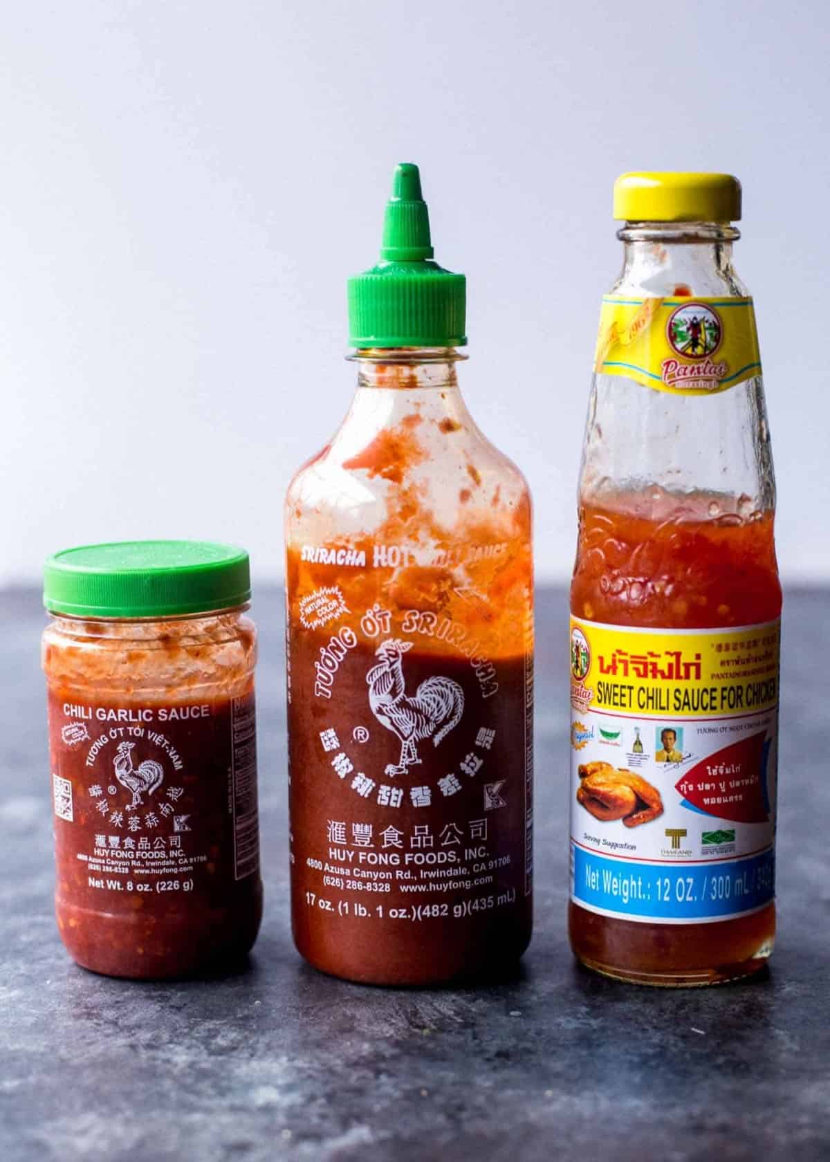 hot sauces used in Thai cooking on a grey countertop