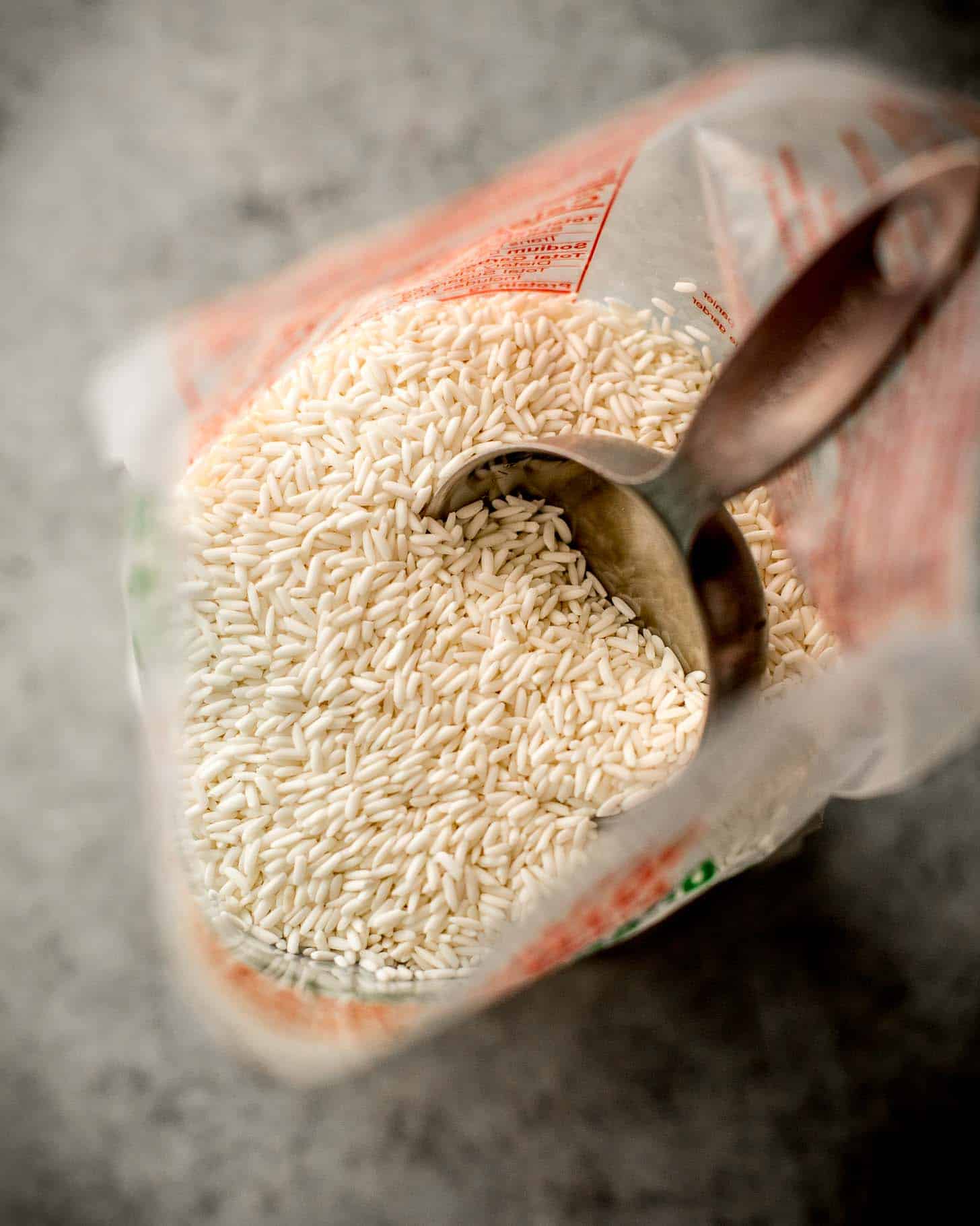 overhead image of a measuring cup in a bag of Thai sweet rice