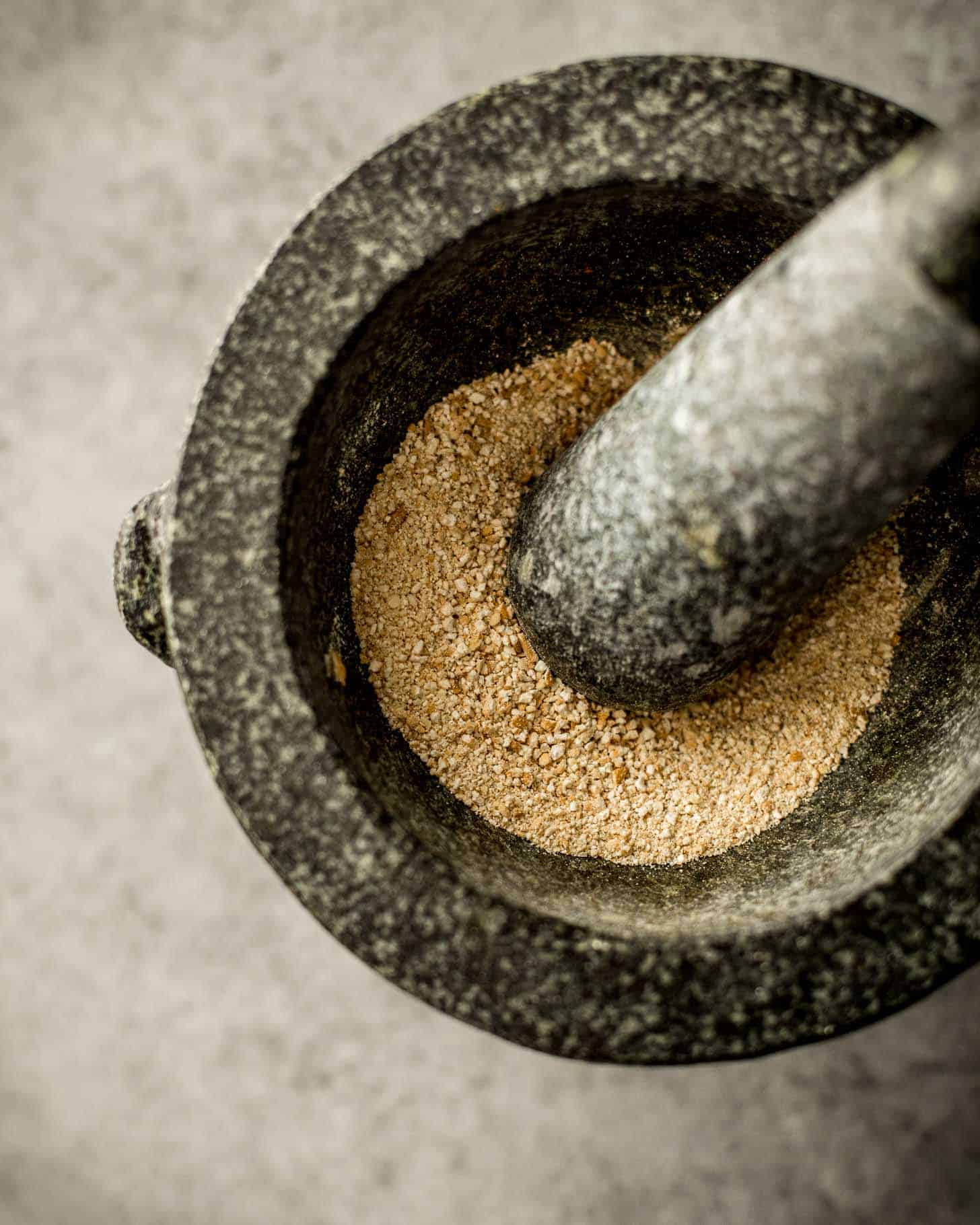grinding rice with a mortar and pestle