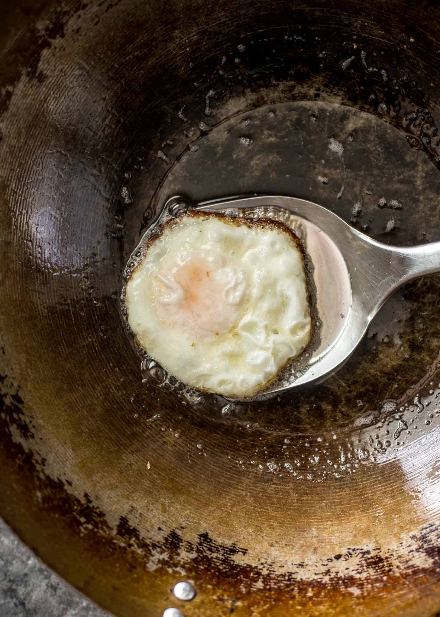 overhead image of a wok fried egg on a spatula