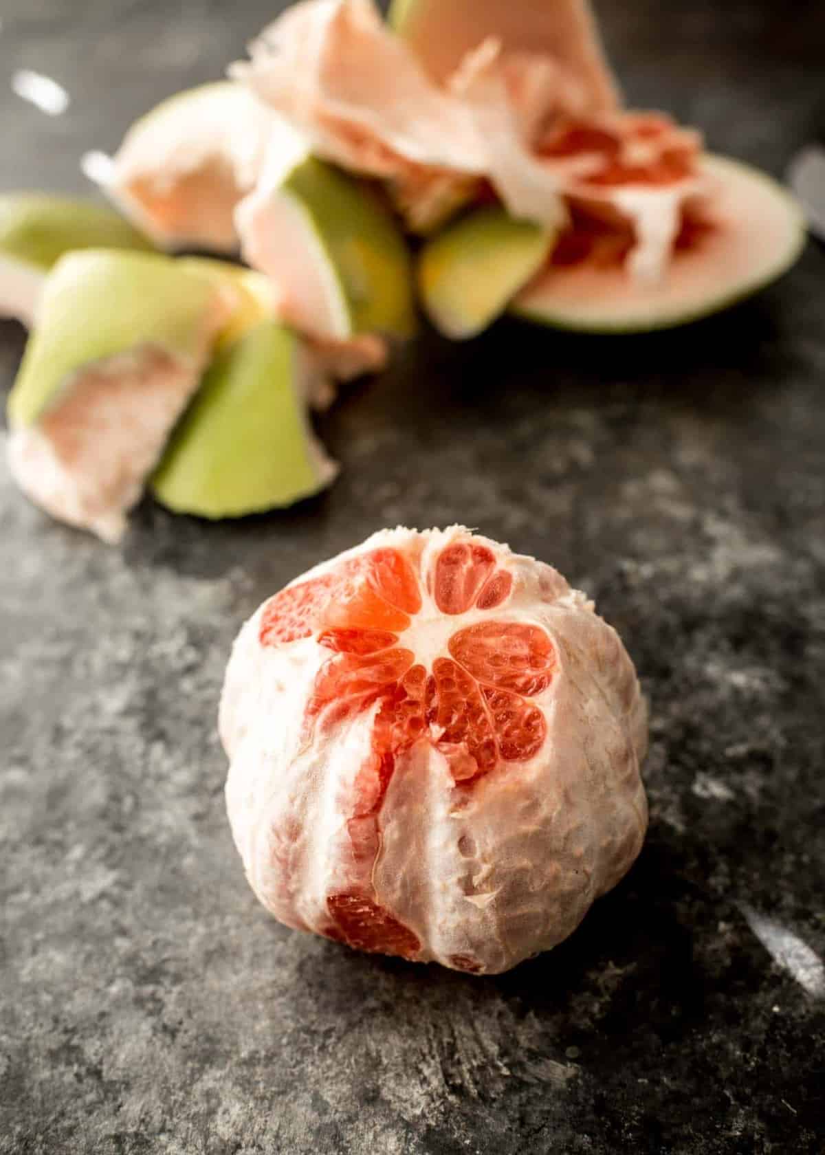 a peeled pomelo on a grey countertop