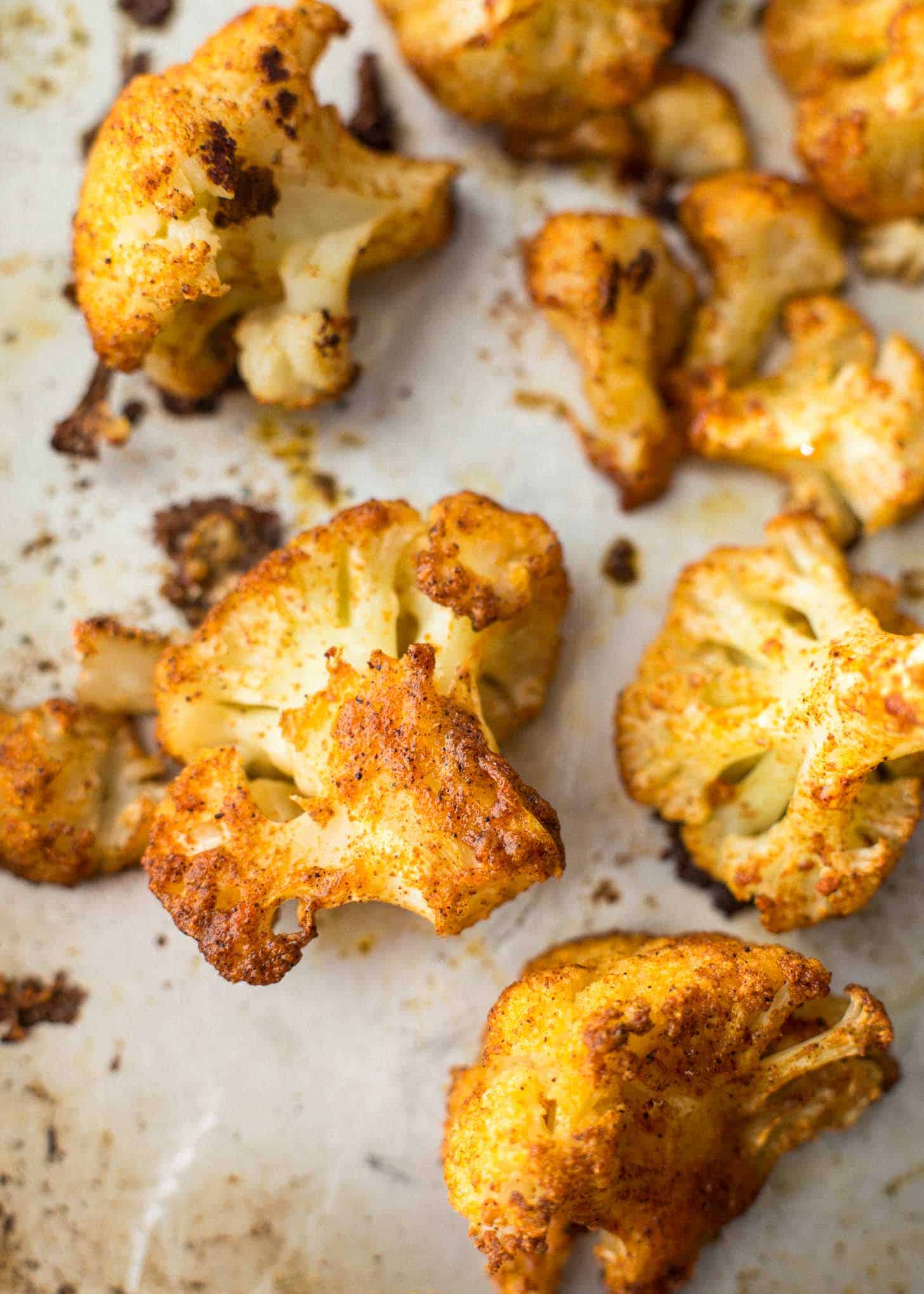 overhead image of roasted cauliflower on a parchment lined sheet pan