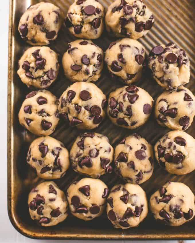 chocolate chip cookie dough in balls on a sheet pan