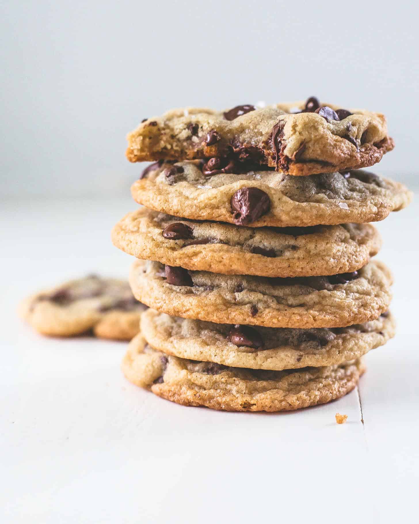 chocolate chip cookies stacked on a white table