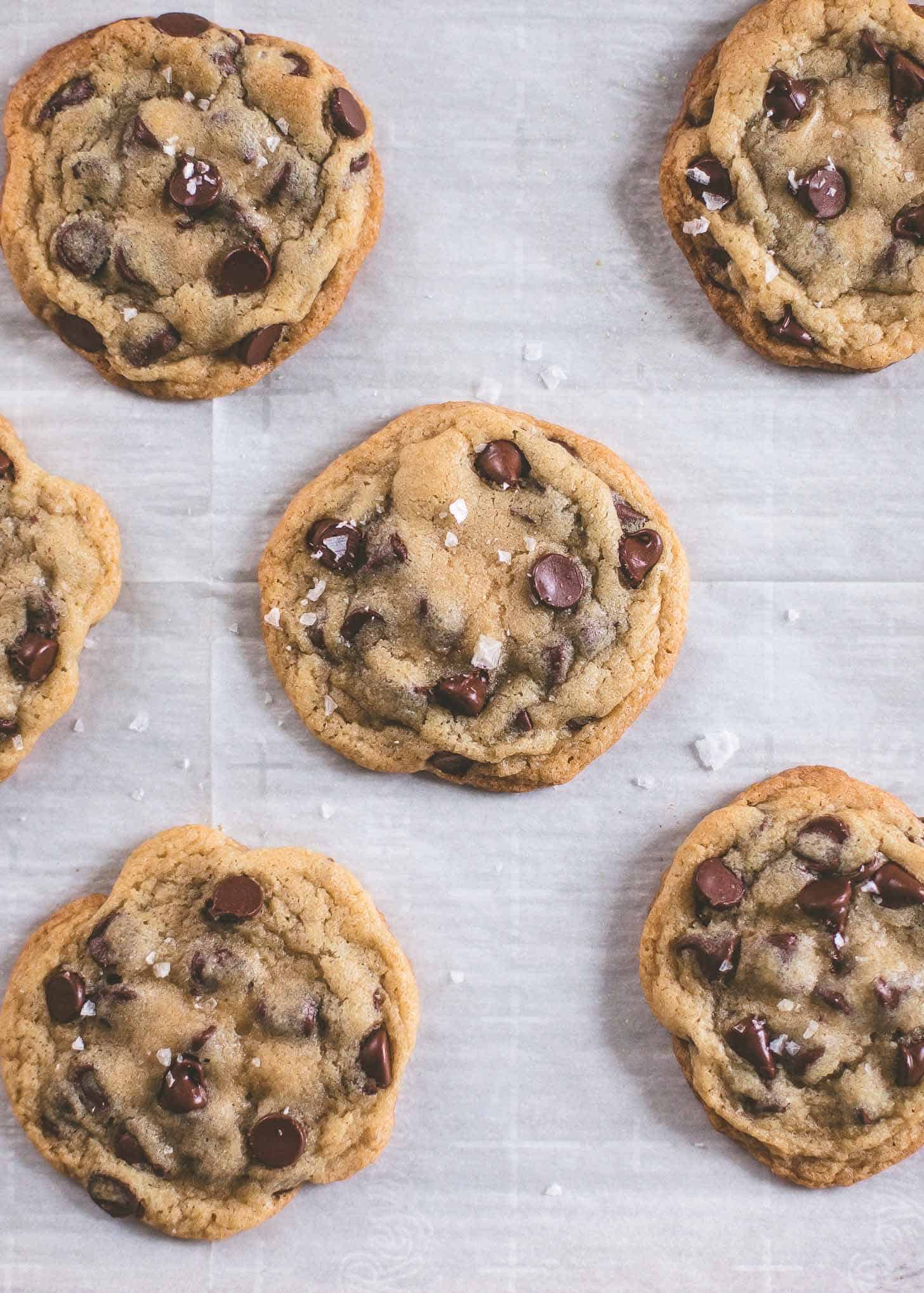 overhead image of chocolate chip cookies after baking, topped with sea salt