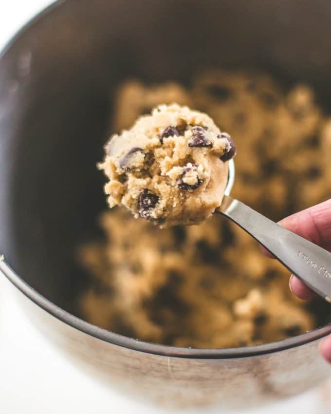 a scoop of chocolate chip cookie dough in a teaspoon over a mixer