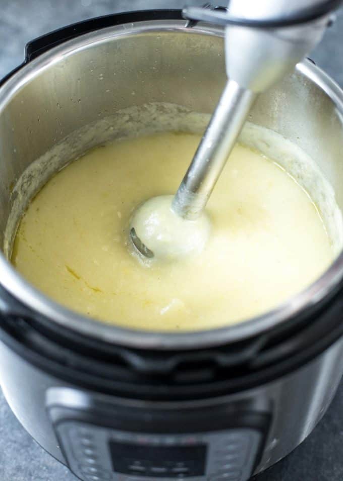 stirring instant pot potato leek soup in an instant pot with an immersion blender