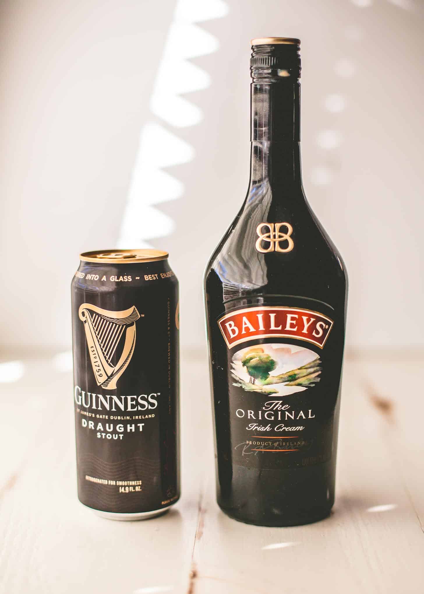 a can of Guinness and a bottle of Bailey's on a white tabletop