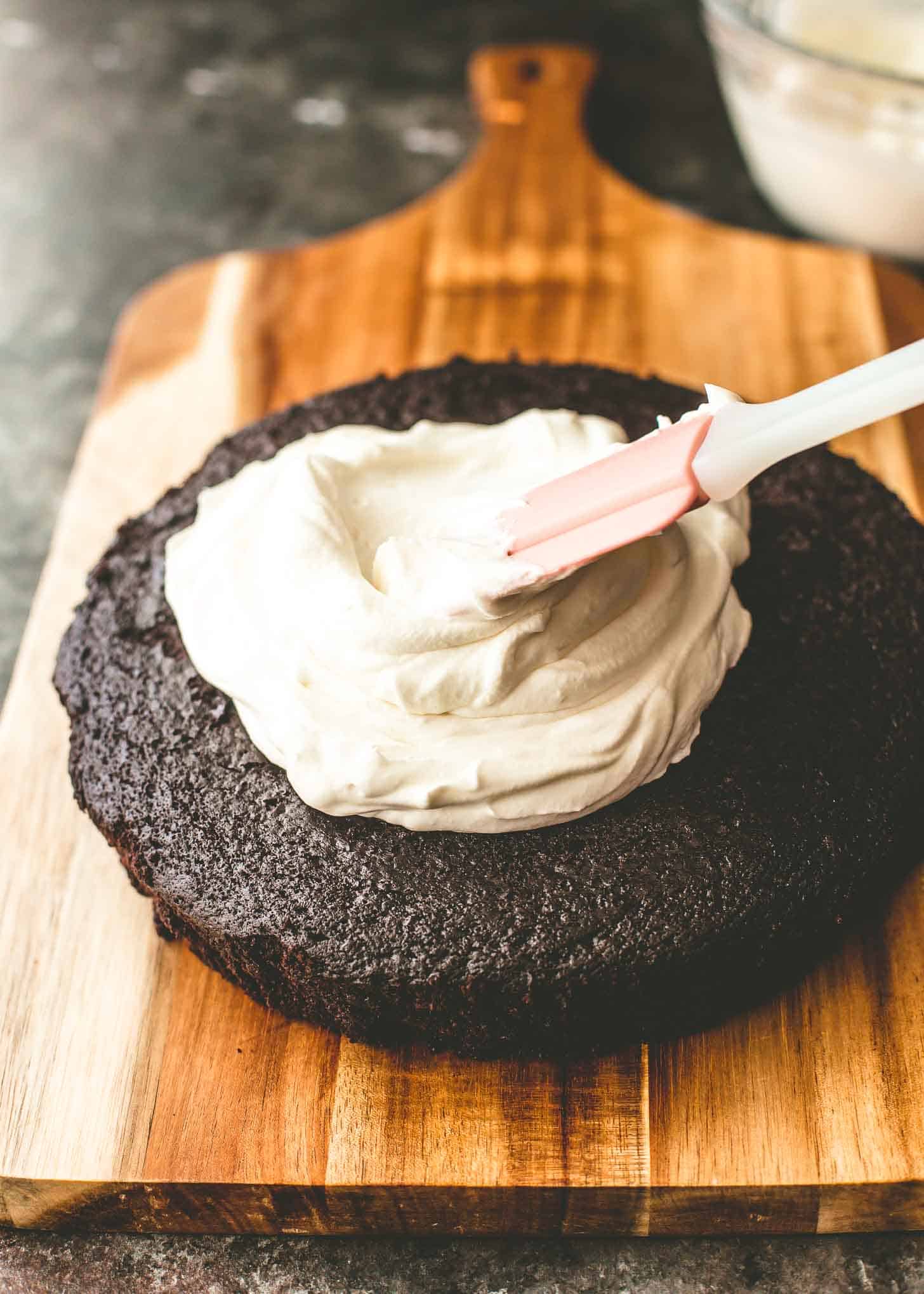 frosting a chocolate cake with a silicone spatula