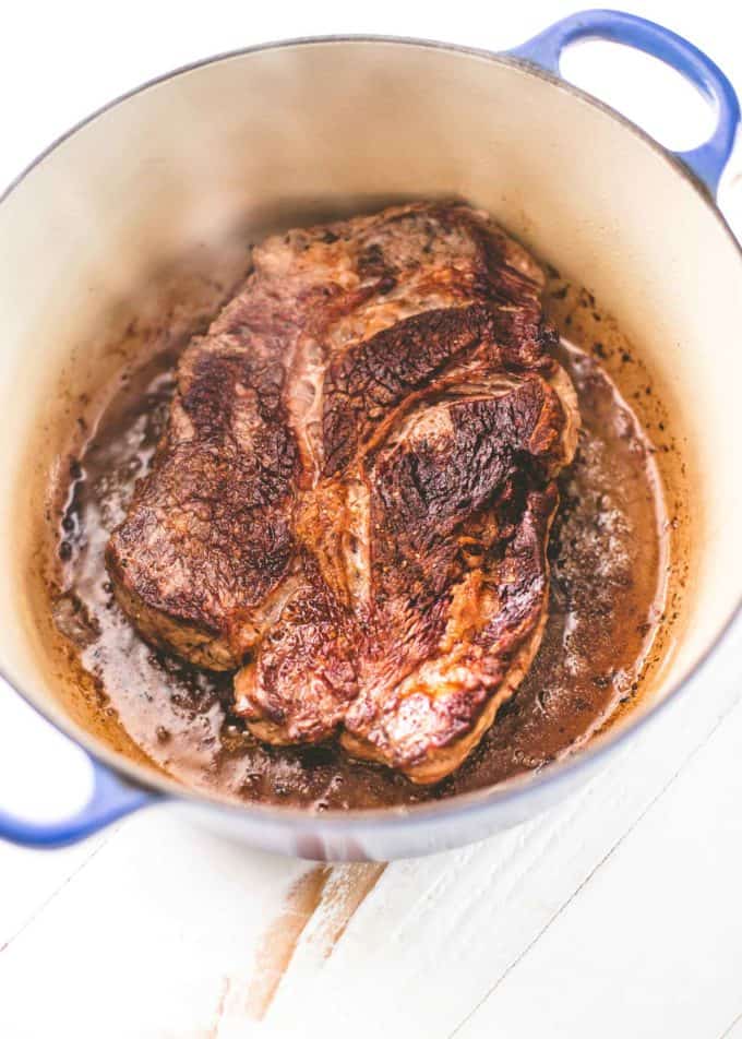 beef roast in a dutch oven on a white table