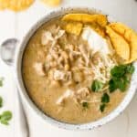 slow cooker white chicken chili in a white enamelware bowl with corn chips