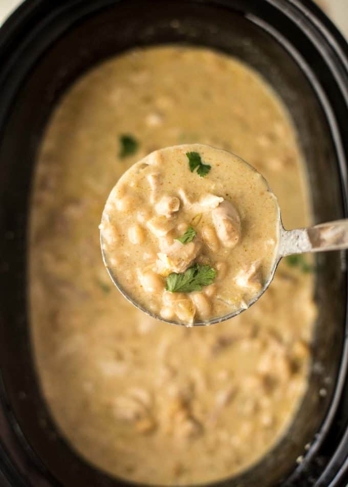  a spoonful of slow cooker white chicken chili over a slow cooker