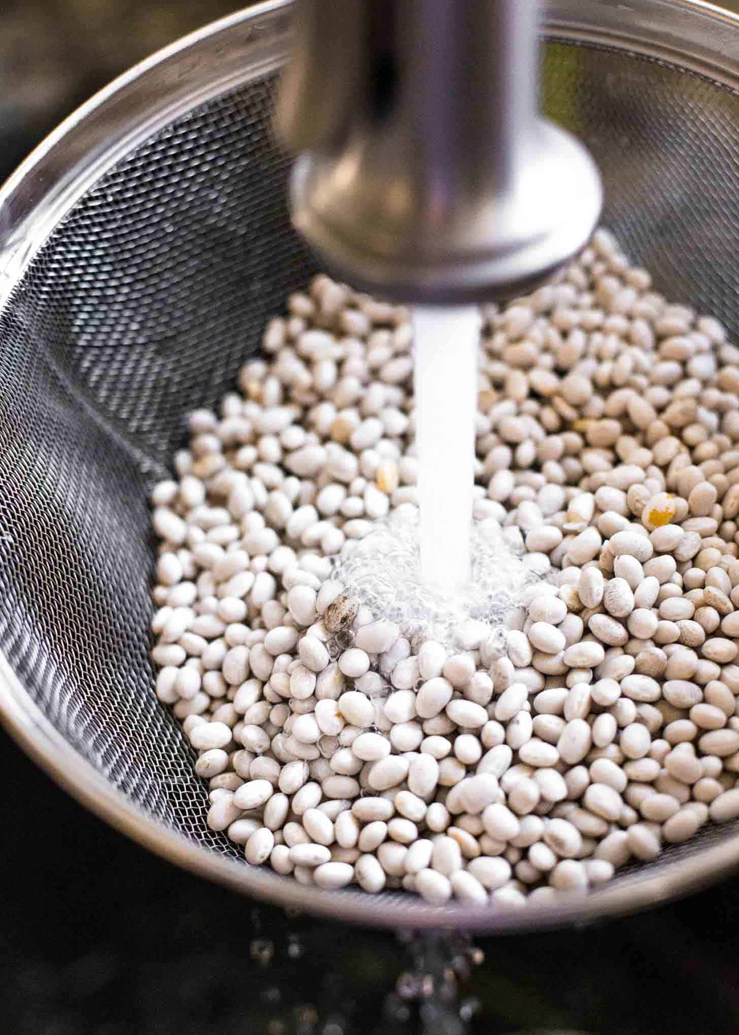 rinsing dried navy beans in a colander