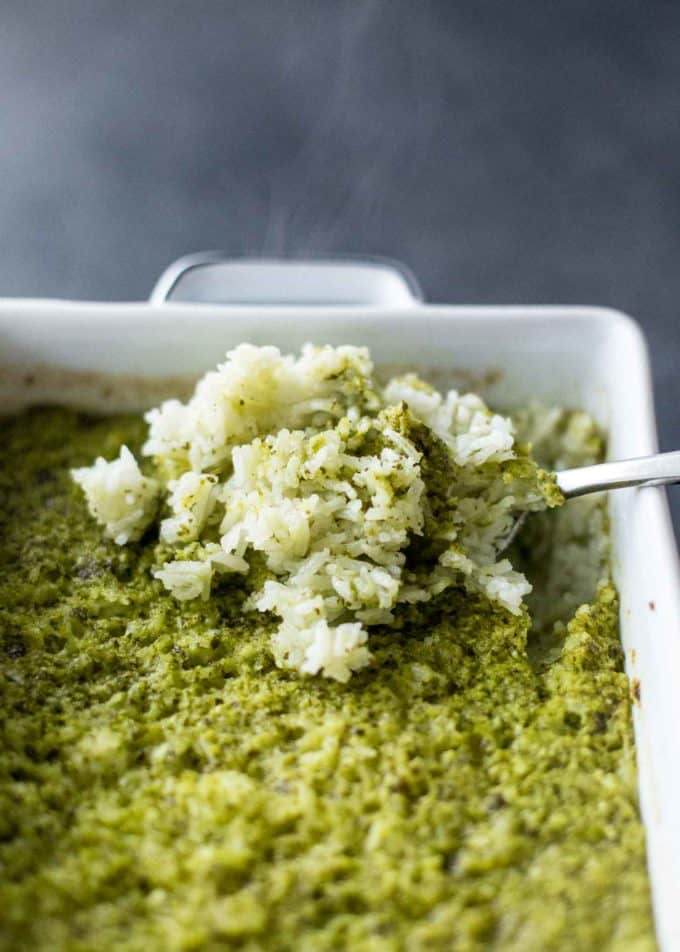 Baked Green Rice in a white baking dish with a spoon