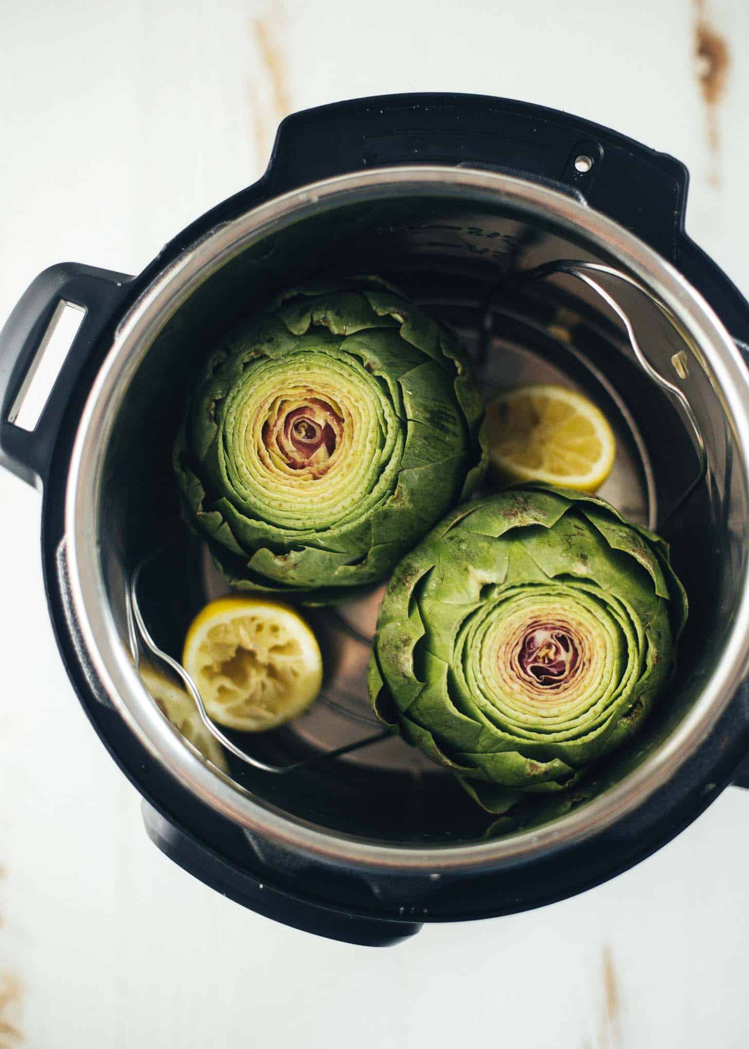 overhead image of artichokes and lemons in an instant pot